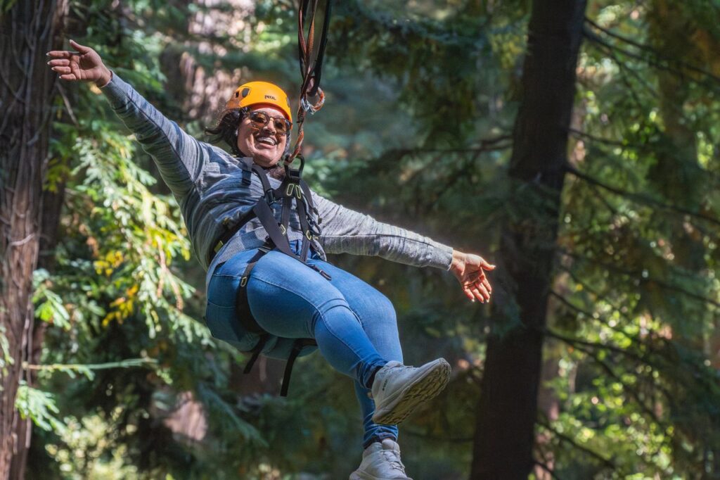 Woman ziplining through a lush forest, embracing adventure and enjoying the thrill of nature.